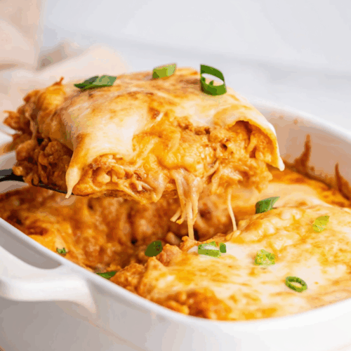 Chicken Enchilada Casserole with melted cheese, corn tortillas, and savory sauce in a baking dish