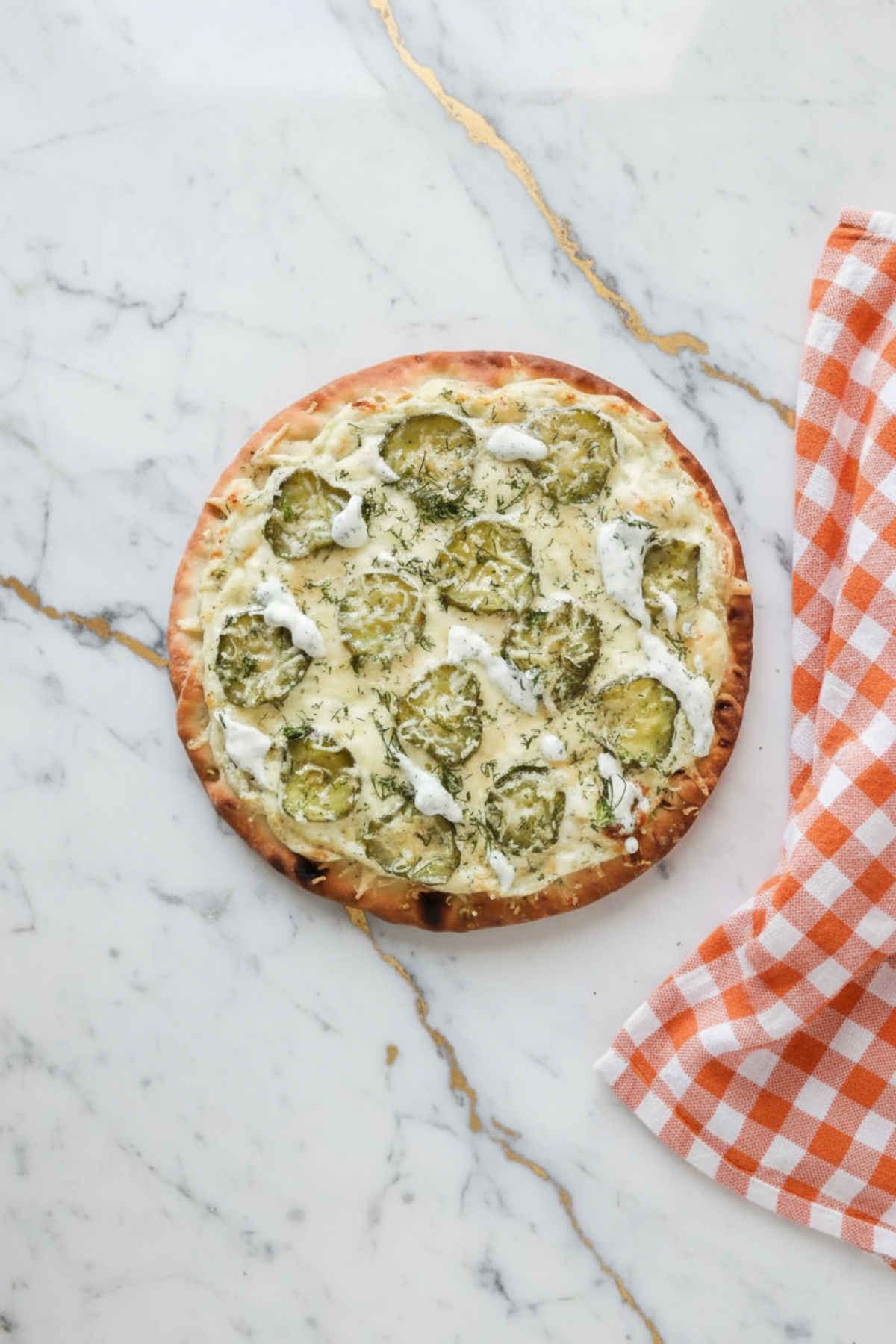 Dill Pickle Pizza topped with sliced pickles, melted mozzarella cheese, and fresh dill on golden crust