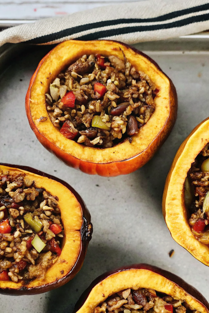 Hearty Stuffed Baked Acorn Squash filled with savory ingredients and golden roasted edges on a white serving plate
