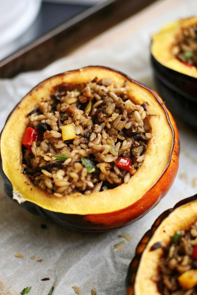 Hearty Stuffed Baked Acorn Squash filled with savory ingredients and golden roasted edges on a white serving plate