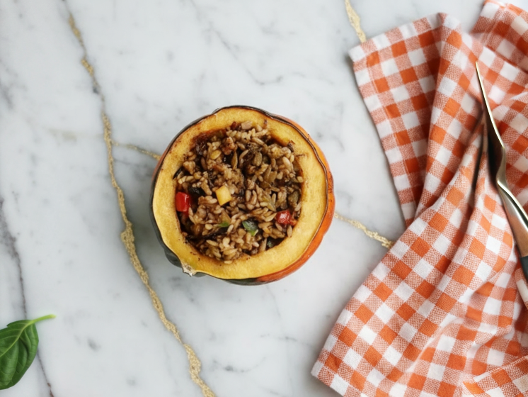 Hearty Stuffed Baked Acorn Squash filled with savory ingredients and golden roasted edges on a white serving plate
