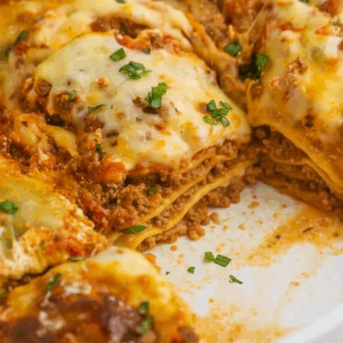 Ravioli Lasagna with melted cheese and marinara sauce in a baking dish, fresh basil garnish on top